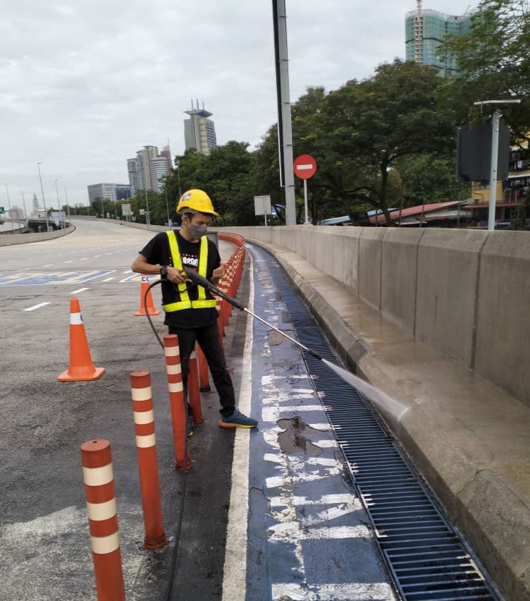 High-pressure jet washing of roadside drains